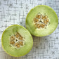 Honeydew melon cut in half to display its green interior.