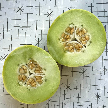 Honeydew melon cut in half to display its green interior.