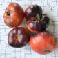 Four red and orange striped tomatoes with anthocyanin shoulders.